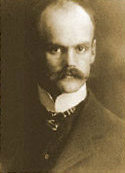Das Foto zeigt Hans Grade in schwarz weiß, ein Portraitfoto es ist ein Mann mit hoher Stirn und Schnurrbart zu sehen