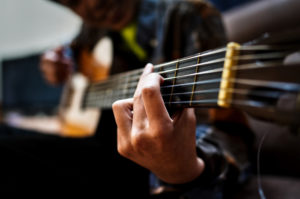 Das Foto zeigt eine Nahaufnahme eines Gitarrenspielers und dient als Beitragsbild zur musikalischen Veranstaltung Sunday Lunch im Hotel Restaurant Fliegerheim in Borkheide bei Beelitz in Brandenburg.